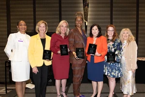 the supervisors holding up awards and smiling with a couple other women.