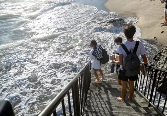 Kids walking down stairs to water and sand.
