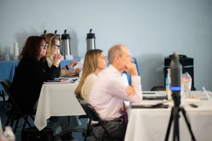 a group of people sitting at tables at an event.