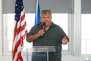 A man speaking at the podium at an event.