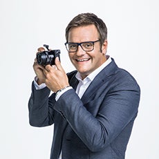 Robert F. Hartlauer mit Kamera seitlich