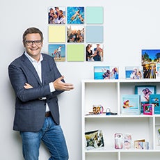 Robert F. Hartlauer mit Fotoausarbeitungsprodukten