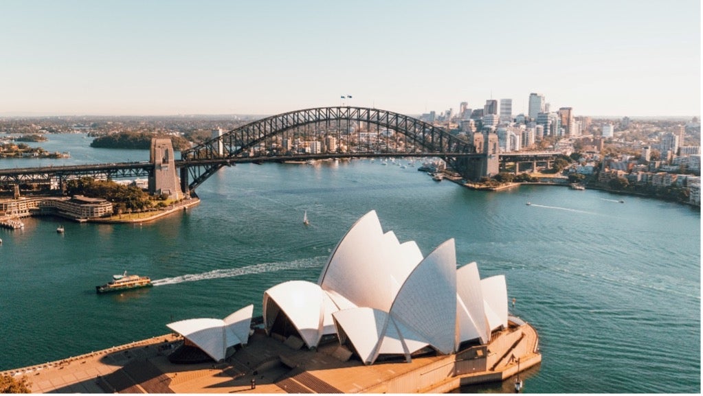 
The Sydney Opera House stands in front of a body of water in Sydney, Australia.