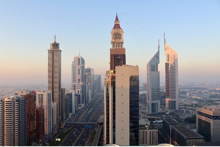 Skyscrapers stand tall against a blue sky in Dubai, the United Arab Emirates