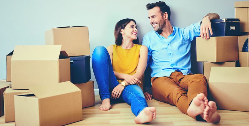 Man and woman sitting next to cardboard boxes