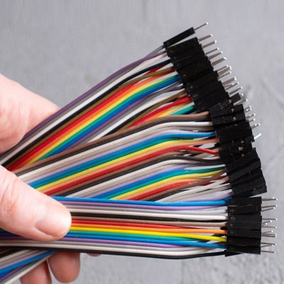 a person holding colorful wires that have been organized perfectly with their ends ready to be placed into electronics