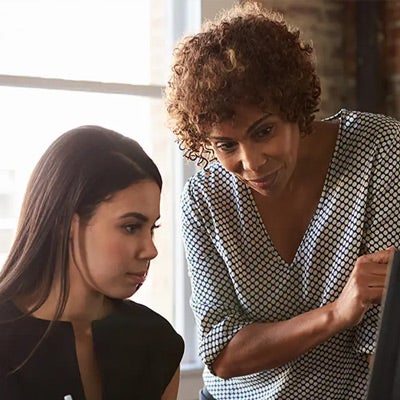 two professional women having a coaching conversation to represent a coaching article that was one of our most-read leadership articles of 2020