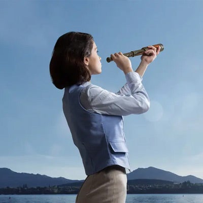 a professional woman with a telescope looking off into the distance 