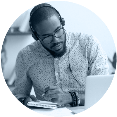 man working on his laptop with head phones on to show that virtual learning is number 2 on the list of 10 hot leadership topics for 2021