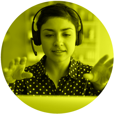 a professional woman with a headset on talking at her computer to show that telecommuting is number 10 on the list of hot leadership topics for 2021