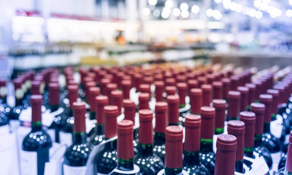 Blurred and close up view group of red wine bottles in cellar at wine section of modern distribution warehouse.jpg