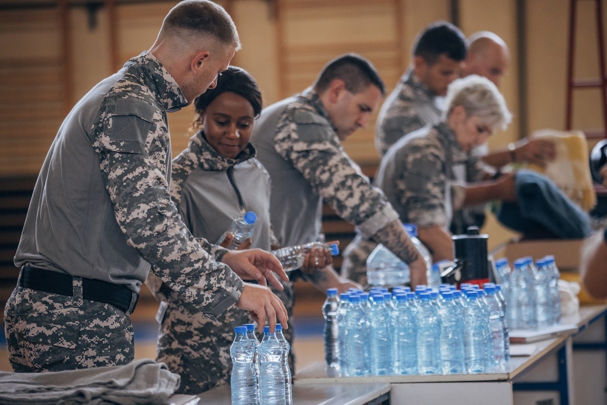 Military members and first responders prepare bottles of clean drinking water