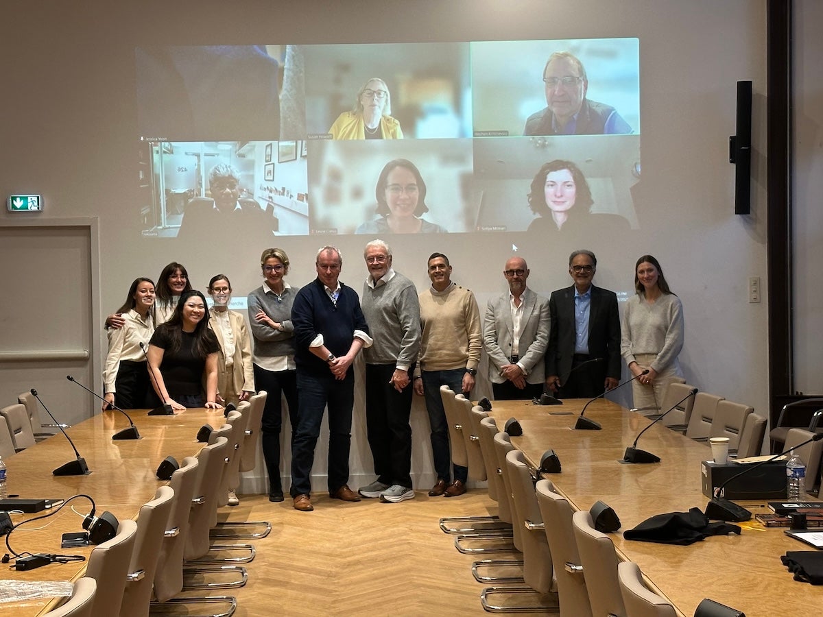 The judges of XPRIZE Healthspan gather both in person and virtually in a conference room.