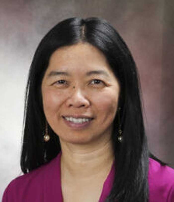 Man Hung, a woman with black hair, wears a fuschia shirt.