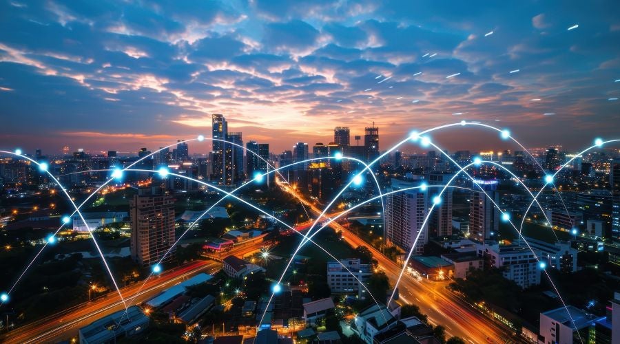 City skyline at dusk with glowing network lines connecting buildings, illustrating high-performance edge computing across urban environments.