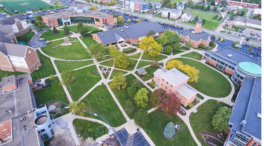 Aerial view of a campus with buildings, pathways, and green spaces.