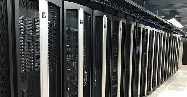 Row of server cabinets in a data center with black and silver designs.