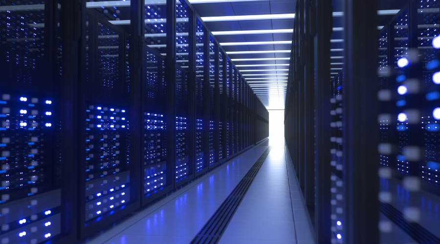 A corridor in a data center with server racks illuminated by blue lights.