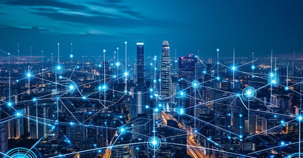 City skyline at night with digital network connections overlay.