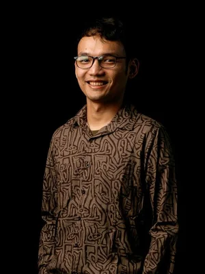 Picture of Rahman standing against a black screen