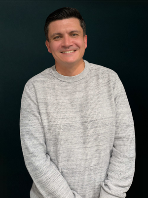 Picture of Jono standing in front of a black screen