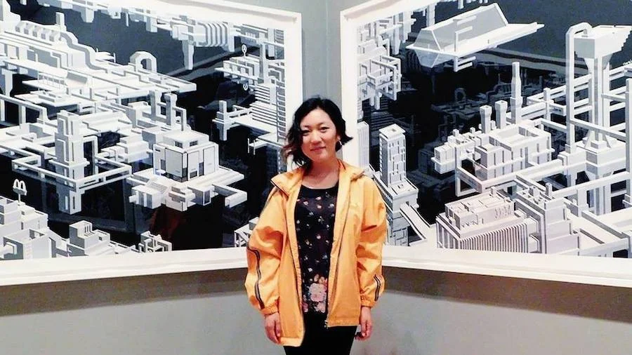 Woman founder smiling infront of wall of art