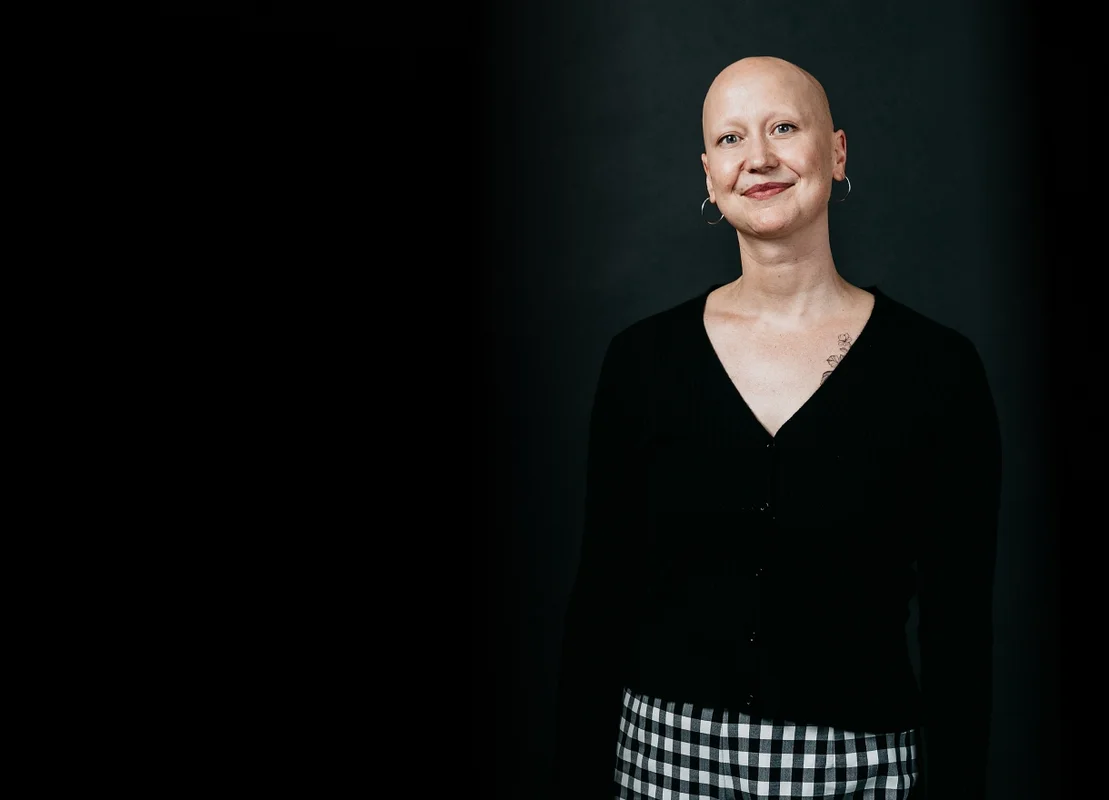 Picture of Luminary employee, Shayna smiling at the camera with a black background.