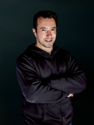 Picture of Dammian standing in front of a black screen