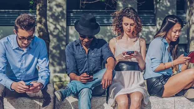 Four young people looking at their mobile phones