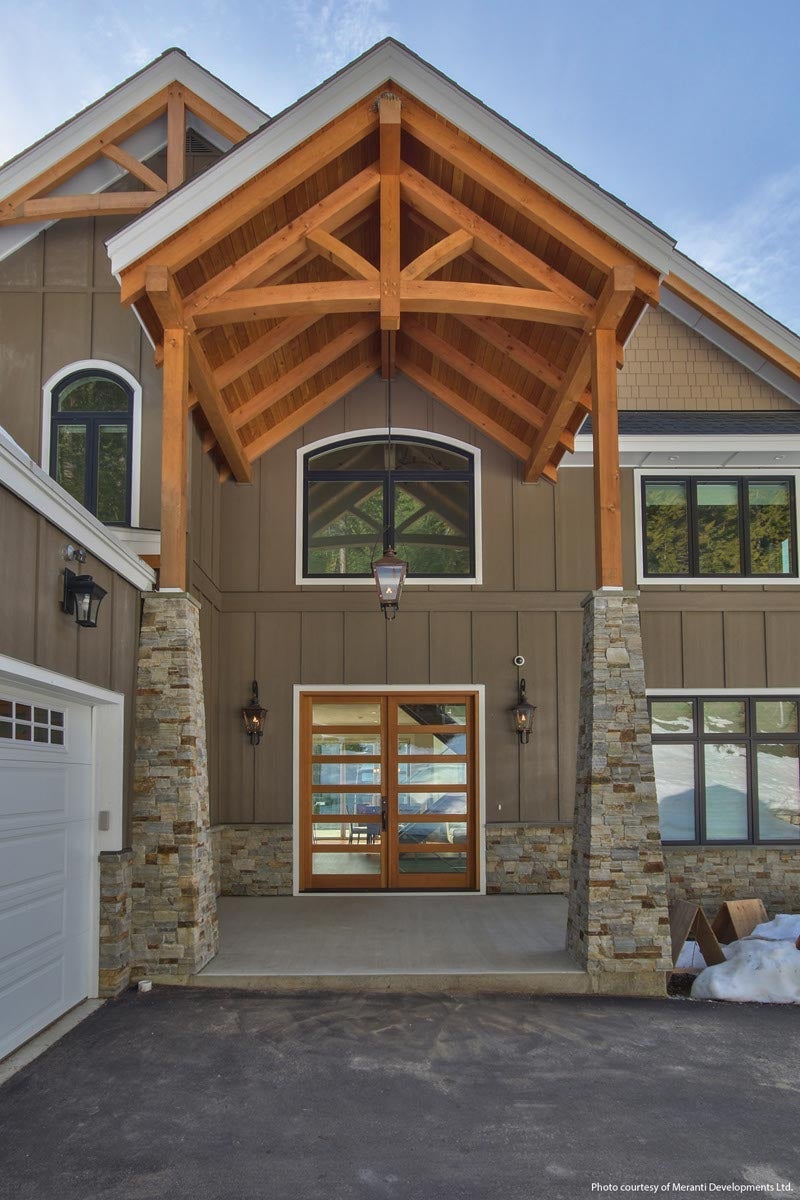 Inswing French entrance door with Vertical Grain Fir wood panels, Crank-out casements with transoms, Stationary casement picture windows with segment head transom