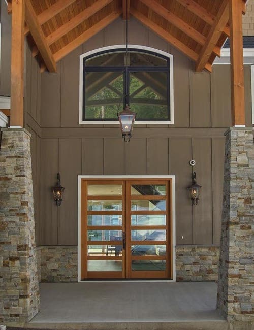 Inswing French entrance door with Vertical Grain Fir wood panels, Crank-out casements with transoms, Stationary casement picture windows with segment head transom