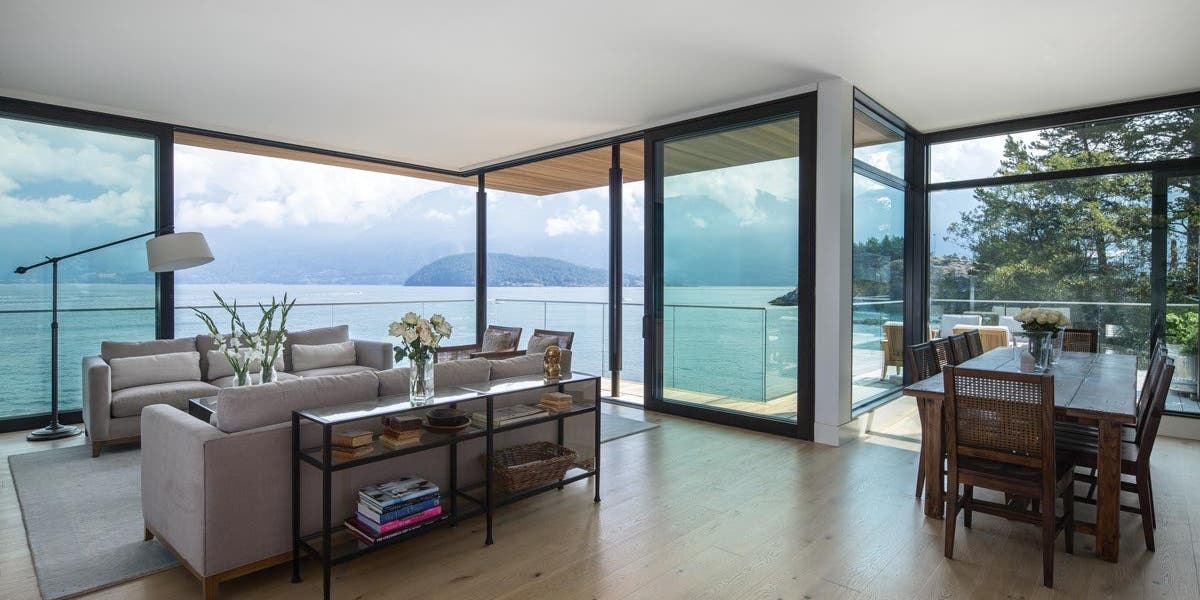 A living room with a large TerraSpan® lift & slide door corner unit with Matte Black hardware and VistaLuxe WD LINE direct set windows
