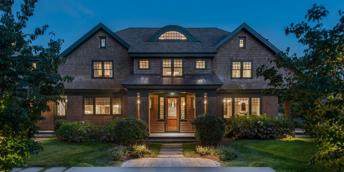 A house with Heritage Series awnings, casements, direct sets, double-hungs, transom, and swing door with a stone walkway