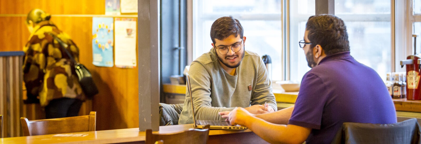Two international students using a laptop.