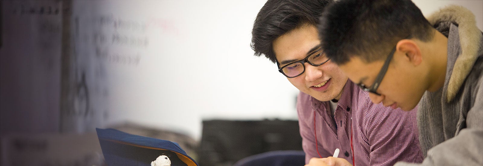 Two students writing in class
