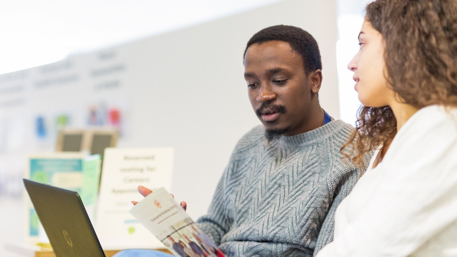 Two students studying at a laptop