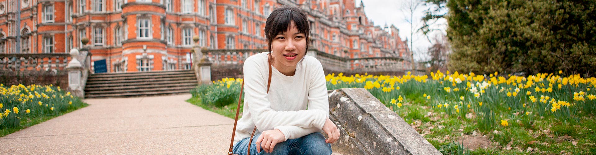 Student sitting on steps outside campus