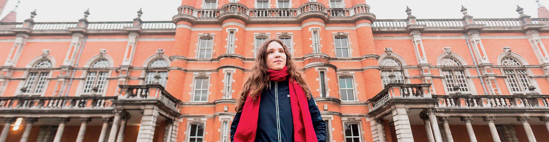 RHUL student standing outside campus building