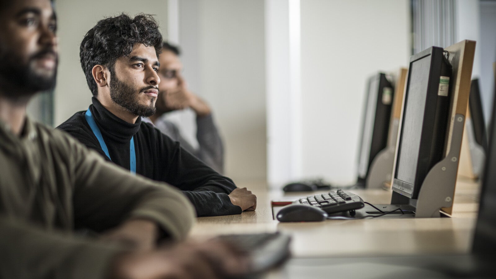 A student in class listening while sitting at a computer