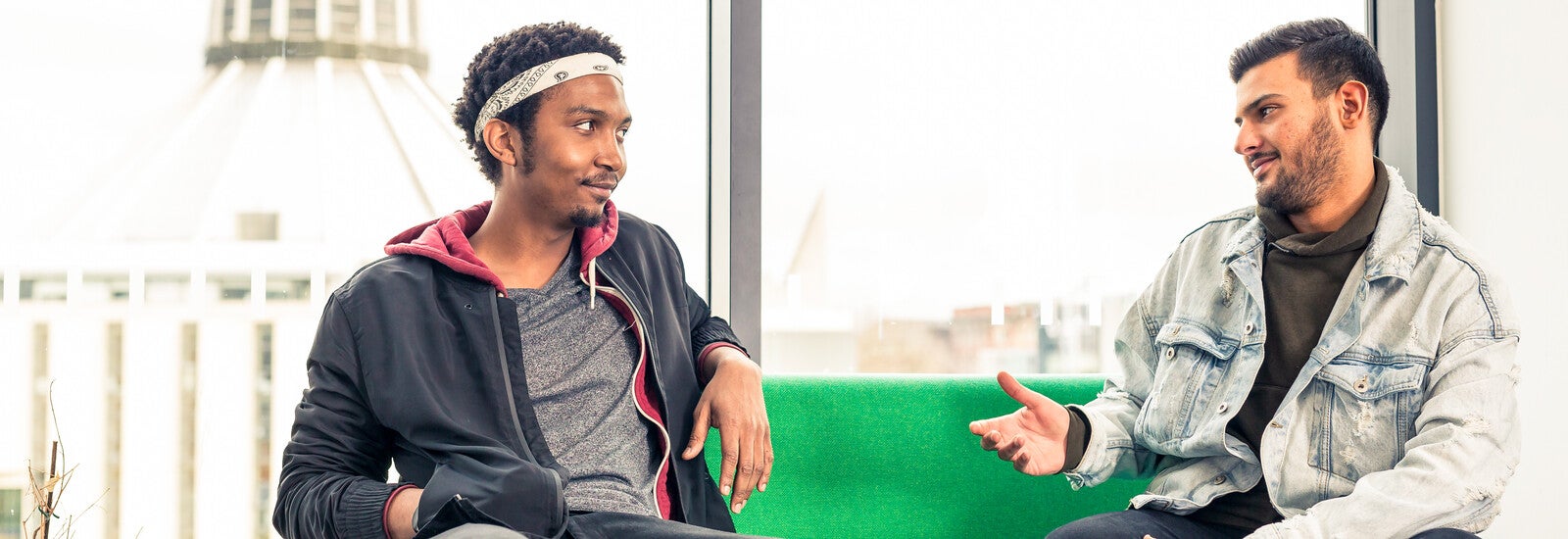 Two students sat on a sofa.