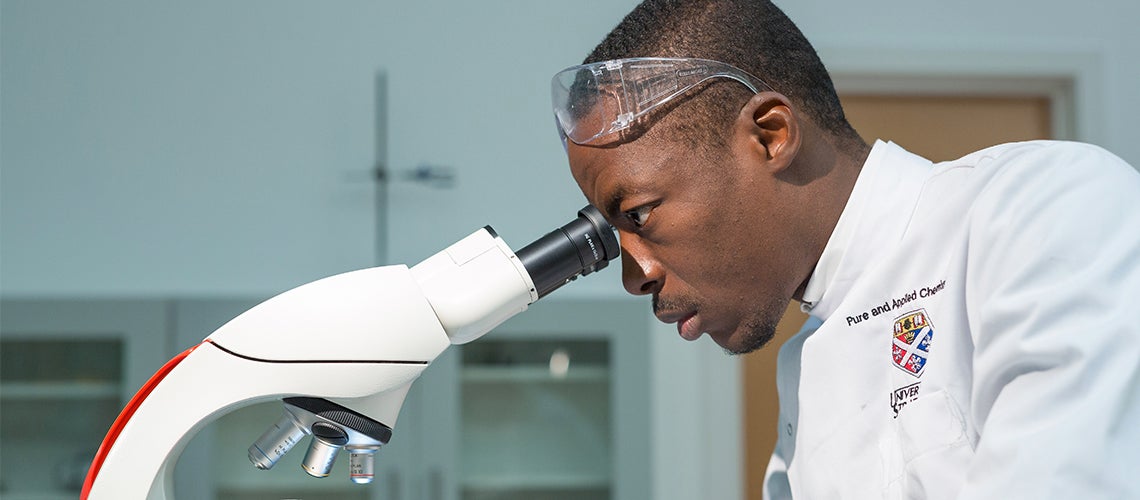Strathclyde science student looking through microscope