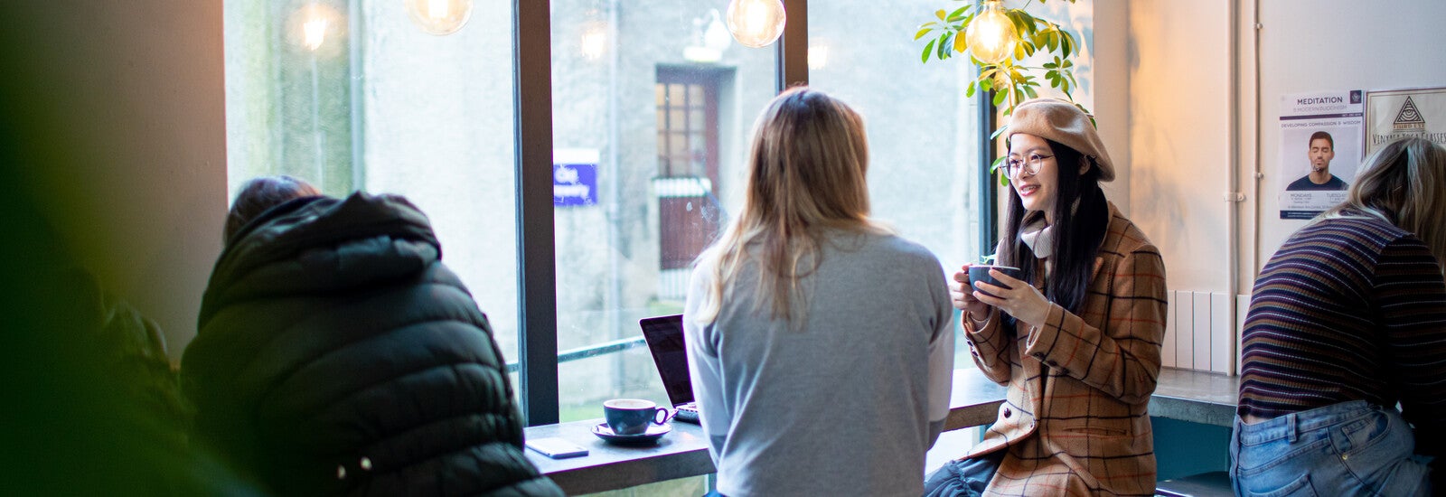 Two students drinking coffee in a cafe