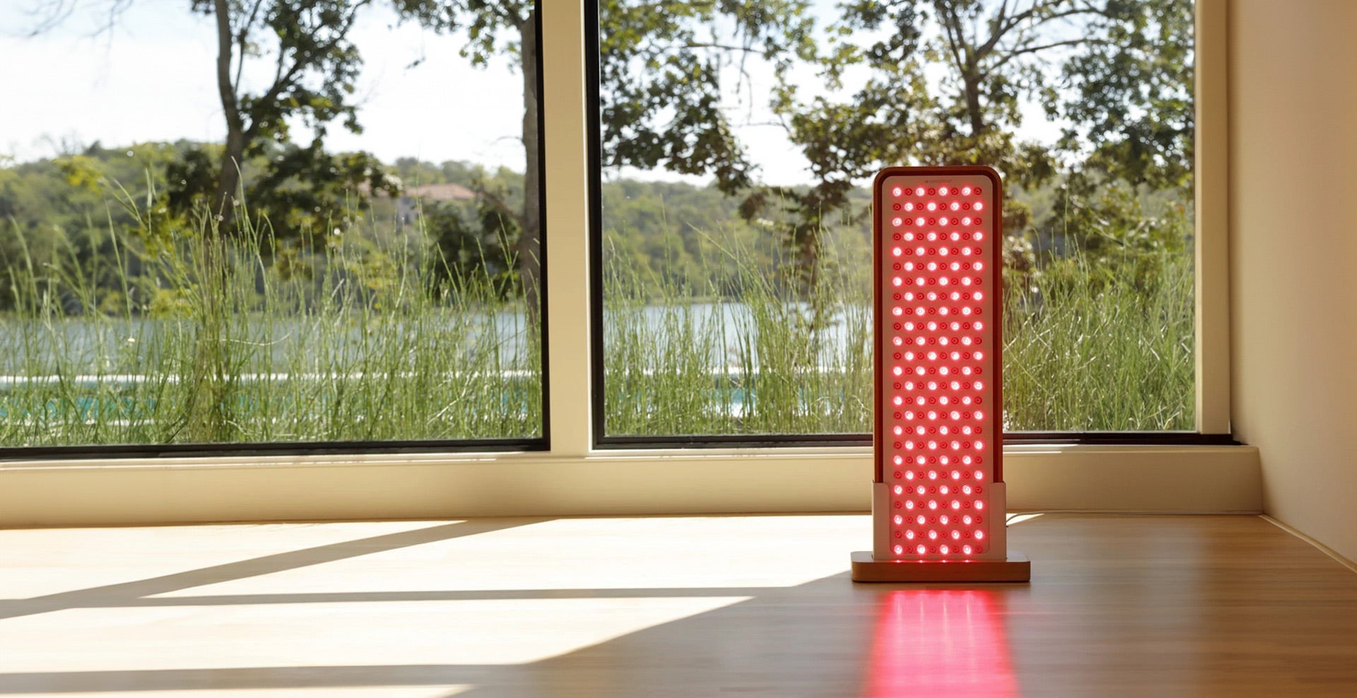 Sunlighten's RED Light Panel sits in front of a window.