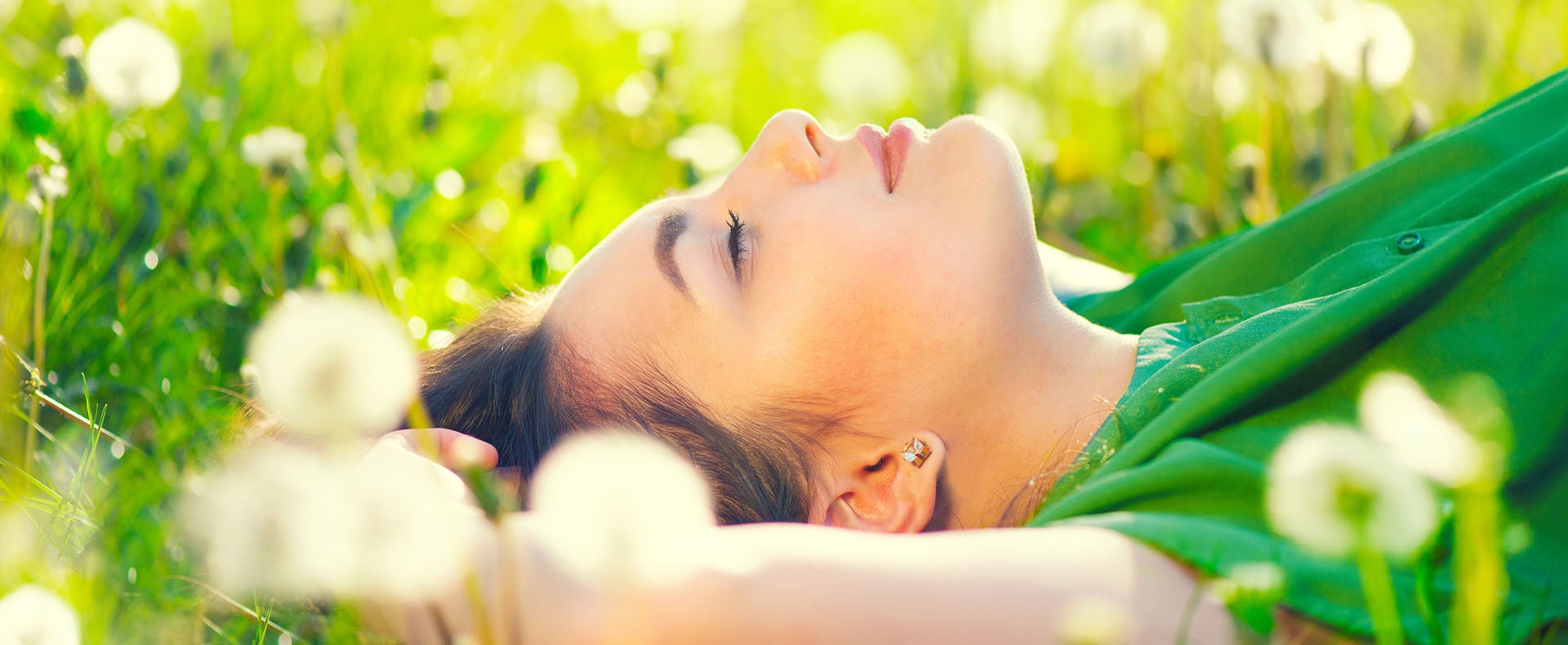 Woman laying in a field of dandelions