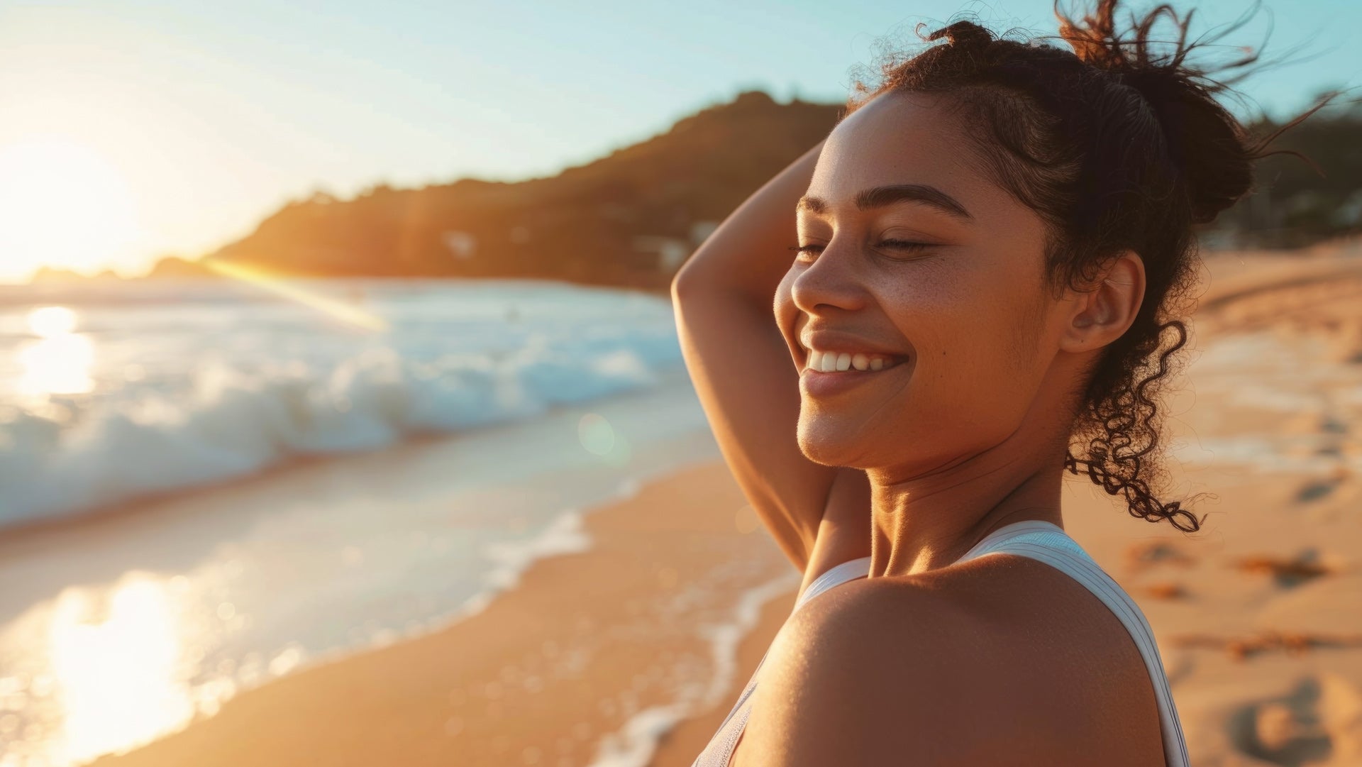 A woman on the beach enjoys the sunlight.