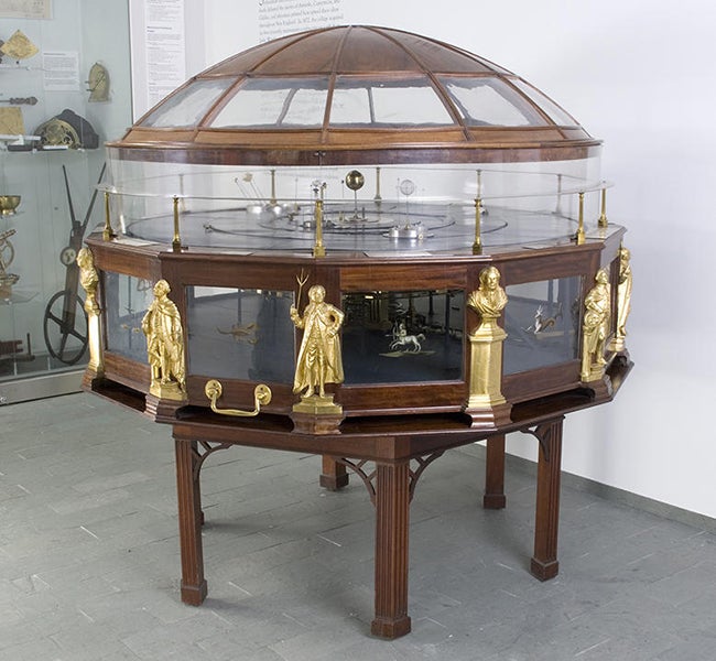 Joseph Pope orrery, completed in 1787, with brass busts and statuettes of Isaac Newon, Benjamin Fannklin, and James Bowdoin II around the base, repeated 4 times, now in the Putnam Gallery, Harvard Science Center; Franklin is the figure at center, Newton is the bust at right, and Bowdoin is to the left of Franklin. (chsi.harvard.edu)