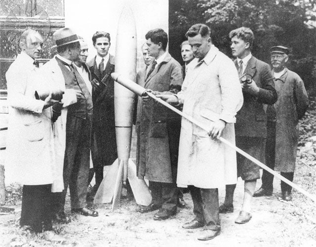 Members of the Verein für Raumschiffahrt (VfR), Berlin, including Hermann Oberth (right of standing rocket) and Wernher von Braun (second from right), photograph, 1930 (Wikimedia commons)