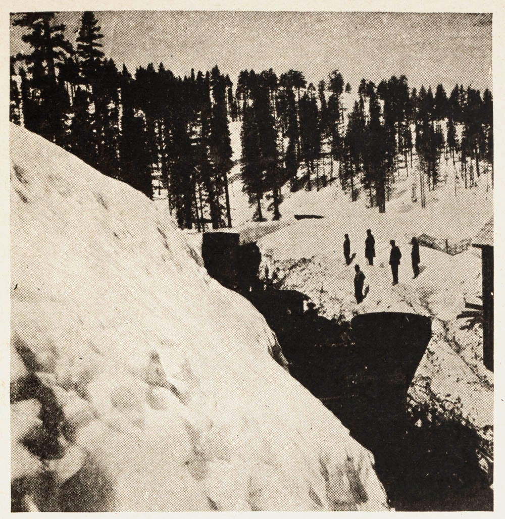 Onlookers observed as a plow attempted to clear massive snow drifts.