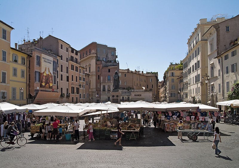 Typical activity on market days at the Campo de’ Fiori, Rome, which the bronze Bruno watches over (Wikimedia commons)