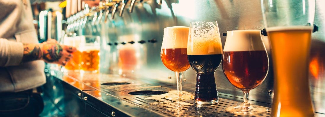 Glass of beer with barrel, bottle and fresh hops still-life